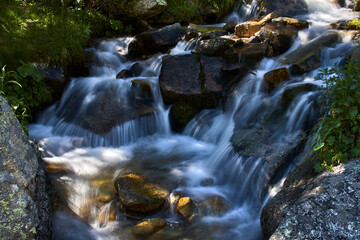 Fototapeta na wymiar Waterfalls among the rocks of a small river