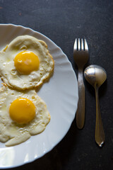Close up of egg poach, sunny side up on a plate.