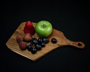 photo of wooden cutting board products and wooden trays, by adding properties to a variety of fresh fruit. Looks very attractive and elegant.