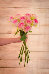 Women hand holding a bouquet of Esperance roses variety, studio shot, pink flowers
