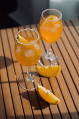 Glasses of traditional Italian aperitif on wooden table at terrace.