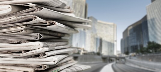 Pile of newspapers stacks on blur street background