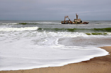 Shipwreck in Atlantic Ocean on the stormy weather and waves crashing at the seacoast, Skeleton Coast, Namibia, Africa