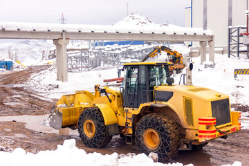 View of the yellow bulldozer in the construction site. A bulldozer or dozer is a crawler equipped with a substantial metal plate used to push large quantities of soil, sand or rubble.