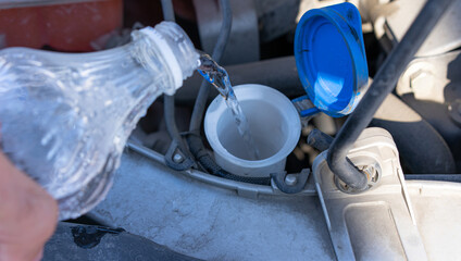 Water is poured into the expansion barrel of the car