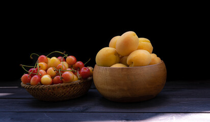 Naklejka na ściany i meble Cherry and apricots on a wooden background