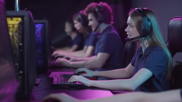 Modern cybersport team players sitting in front of computers challenging difficult video game in competition event