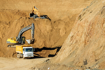 Excavators are digging, excavation and loading to dump trucks in the construction site.