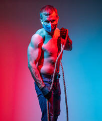 Handsome naked torso man in gloves and face mask with a rope