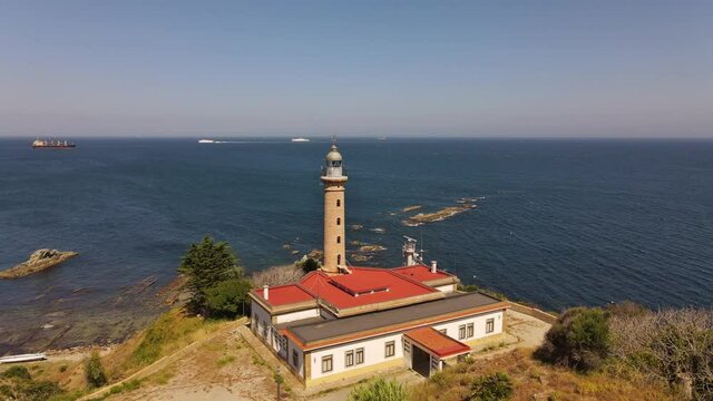 The drone flies a quarter circle around the Carnero lighthouse. In the background you can see the famous rock of Gibraltar and the bay of Algeciras with ships.