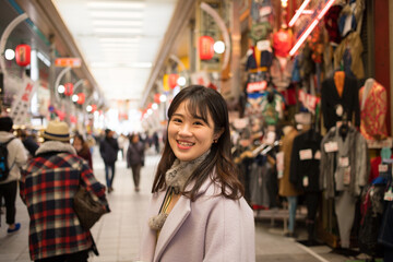 Fototapeta premium 冬の商店街にいる綺麗な若い女性