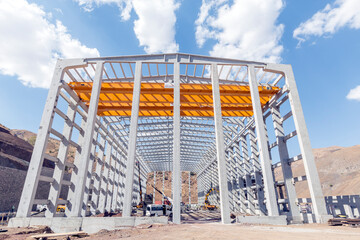 View of the prefabricated (precast) reinforced concrete industrial building. The entire building is erected with precast concrete elements, starting with the foundation, the columns, beams and walls.