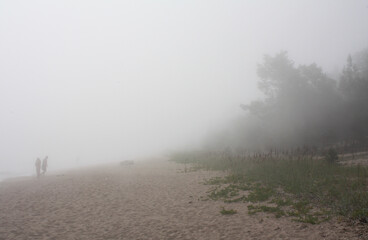 people in the fog on the lake shore