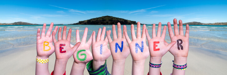 Children Hands Building Colorful English Word Beginner. Ocean And Beach As Background