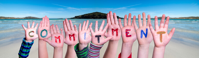 Children Hands Building Colorful Word Commitment. Ocean And Beach As Background