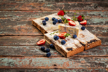 Blue and brie cheese. On a wooden background. served with blueberry and strawberry. The concept of eco products. Background image. Copy space