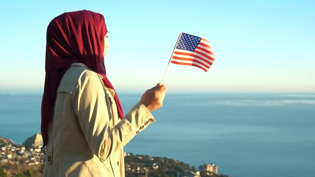 Muslim Americans assert solidarity with Black Lives Matter movement. Muslim woman in hijab with flag of the United States