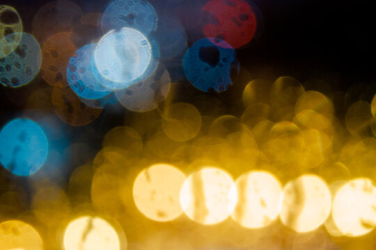 night light behind the wet window. abstract blur background