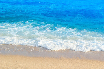 Fototapeta na wymiar wave of blue ocean on sandy beach. Background.
