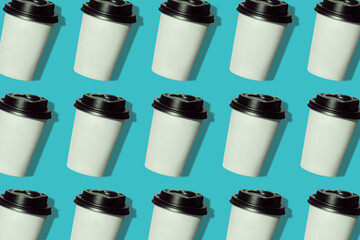 Coffee to go regular pattern made of photo on a turquoise background. Kraft paper cups with black lids and natural hard shadows. Lifestyle take away hot drinks concept. Trendy flatlay, top view.