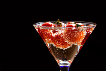 Tomato floats in water with bubbles in glass glass glass on white background.