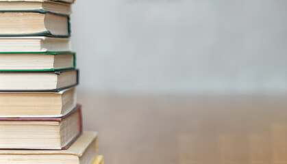 A stack of books (old) on the floor on a light blurry background. Copy space.