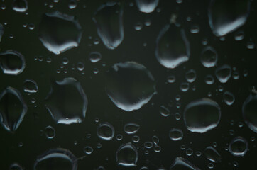 Rain drops on window glasses surface with cloudy background . Natural Pattern of raindrops on...
