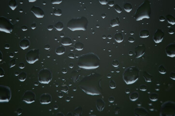 Rain drops on window glasses surface with cloudy background . Natural Pattern of raindrops on cloudy background.