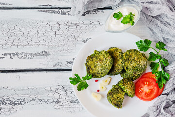 Healthy diet pancakes made from broccoli, spinach, onions, green beans and parsley.  Rustic. On a table of white boards.