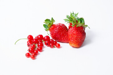 bunch of red currants with three red strawberries on a white background.