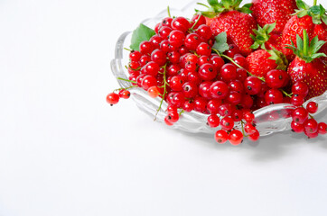 Fruit vase with strawberries and red currants on a white background in the upper right corner of the frame.