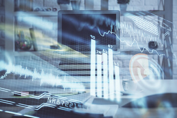 Computer on desktop in office with technology theme hologram. Double exposure. Tech concept.