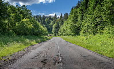 Old asphalt road in a mountain forest.