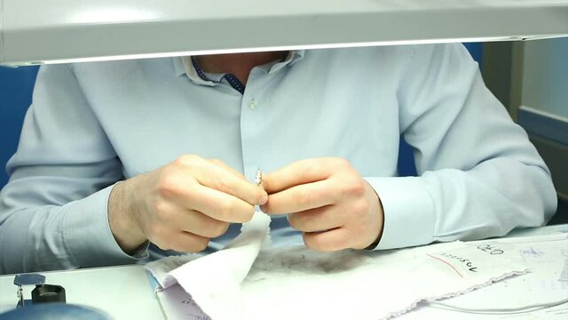 The gemologist checking the diamonds carat and quality package diamond rings in jeweler