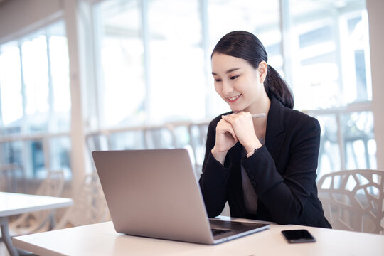 Asian girl with laptop, success happy pose. E-commerce, University education, internet Technology, or startup small business concept. Modern office or living room with copy space