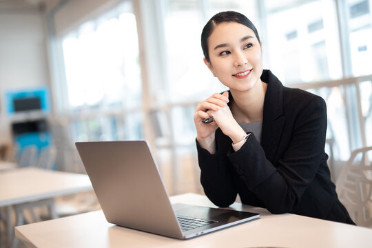 Asian girl with laptop, success happy pose. E-commerce, University education, internet Technology, or startup small business concept. Modern office or living room with copy space