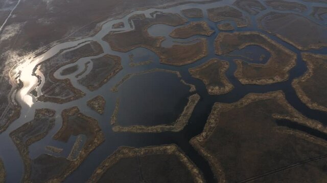 Backward aerial view of shaped Engures lake islands with reflection