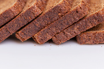 Sliced brown bread. Close-up. White background. Space for text.