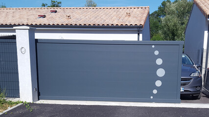 Aluminum modern dark gray metal gate to house with portal to access home garage
