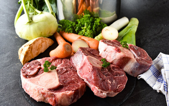 Zutaten f&uuml;r eine Rindfleischsuppe - Rinderbeinscheibe und Gem&uuml;se roh und ungekocht