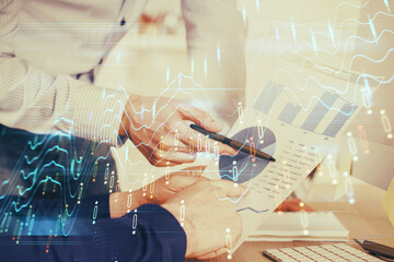 Financial trading graph double exposure with man desktop background.