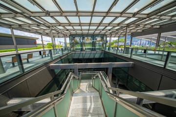 Modern glass elevator and pedestrian stairway entrances.