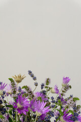 Bouquet of purple wildflowers with lavander and mint close-up on a grey background