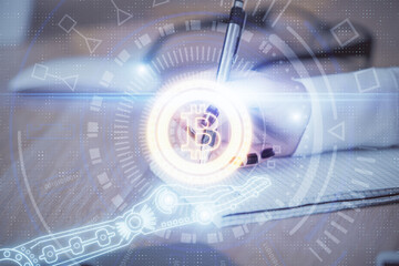 Cryptocurrency hologram over woman's hands writing background. Concept of blockchain. Double...