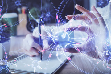 Neuron hologram over hands taking notes background. Concept of research and study. Double exposure