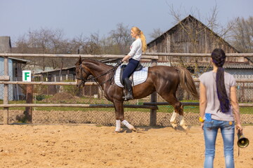 Girl riding a horse gallops in a paddock on a ranch