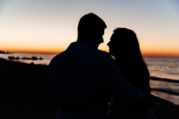 Loving couple in white clothes during a honeymoon at sea walk on the sand at a photoshoot Love...