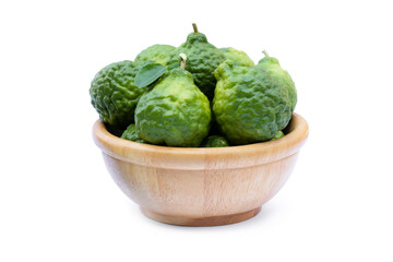 Bergamot or kaffir lime fruits with green leaf in wooden bowl isolated on white background. 