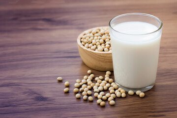 Closeup soy beans with glass of soy milk isolated on old rustic wood table background. Vintage style. Selective focus.