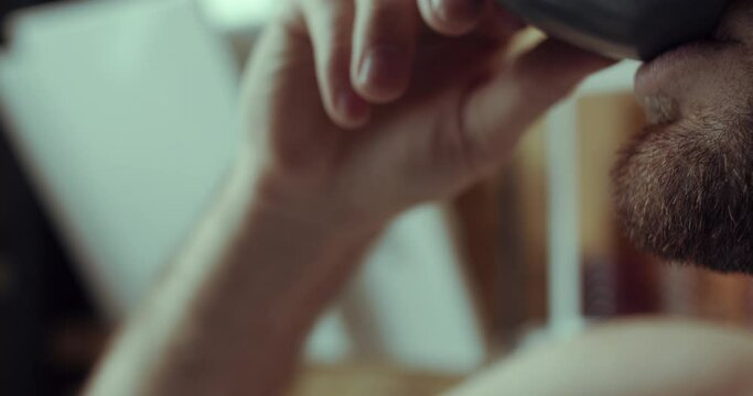 A close up man is drinking his morning tea/coffee